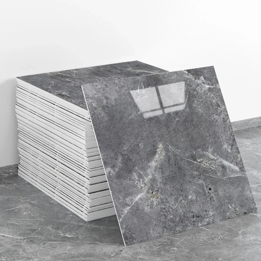 A stack of rectangular gray marble tiles next to a single tile showing veining and a window pattern.