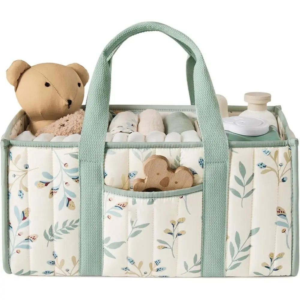 A floral diaper organizer bag in cream and sage green with multiple compartments for baby supplies.