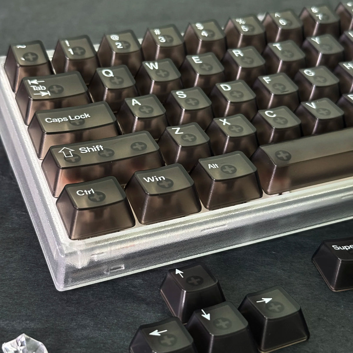 A close-up view of brown translucent PC keycaps for a mechanical keyboard, showing various function keys and modifiers.