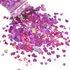 A pile of shiny holographic star sequins in various shades of purple and pink scattered on a white surface.