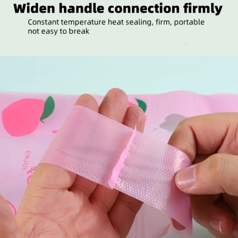 A hand holds a pink, heat-sealed silicone wrist strap or handle connection firmly against a light pink fabric.
