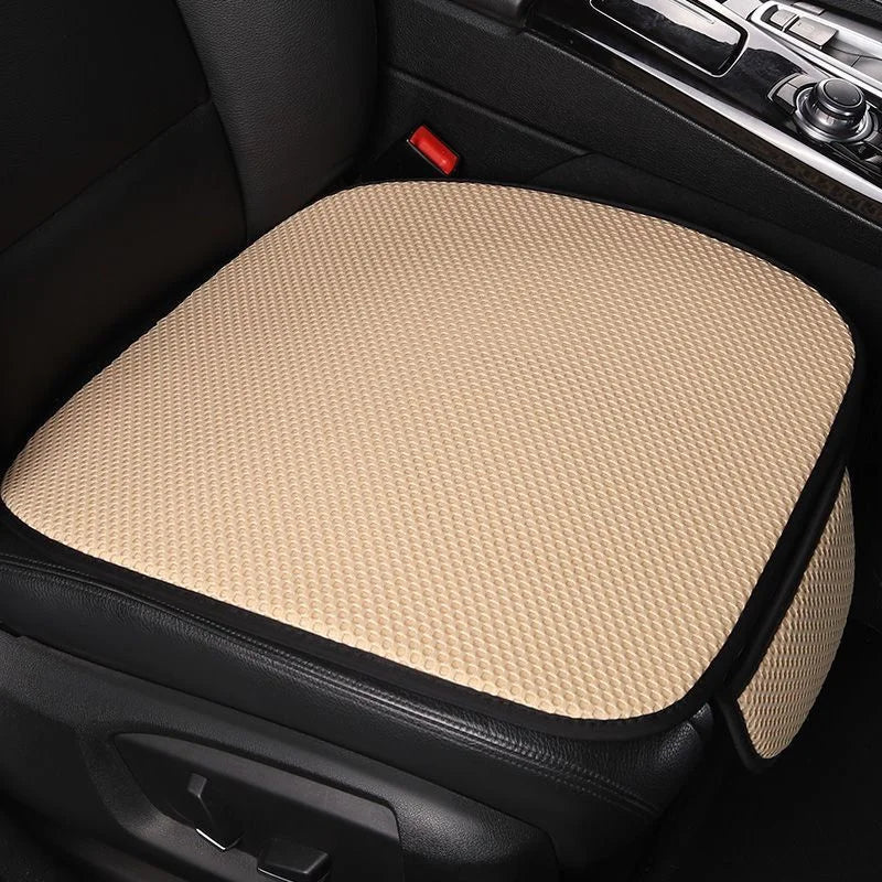 A beige breathable ice silk car seat cushion is shown in a black car interior.