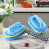 A bright blue sponge cleaning brush with a handle rests on a black wire rack next to a gray towel and red fruit.