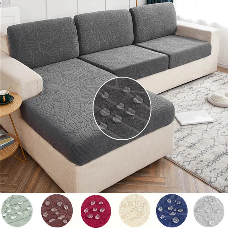 A gray stretch jacquard sofa cover with anti-slip backing shown on a light-colored sofa.