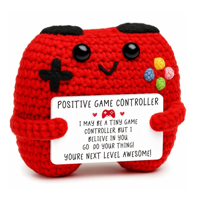Red crochet animal doll shaped like a controller with a positive message card attached