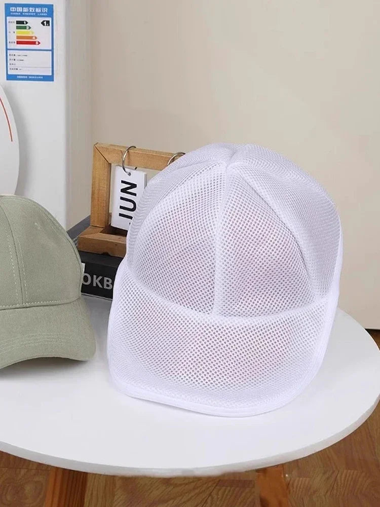 White mesh laundry bag for hats and delicate clothing displayed on a table.