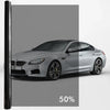 A silver BMW sedan with a dark privacy tint film applied to the windows.