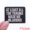 Black embroidered iron-on letter patch with white text that reads At least all the trauma made me hilarious