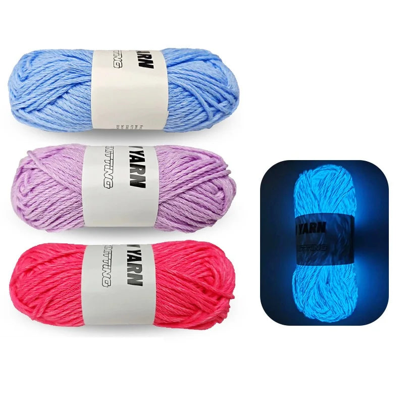 Three skeins of glow-in-the-dark polyester yarn in blue, purple, and pink stacked horizontally.