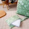 A light green reusable waterproof wet bag set with a white towel is shown on a beige surface.