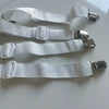 A pack of four white adjustable bed sheet grippers with strong clips laid out on a white surface.