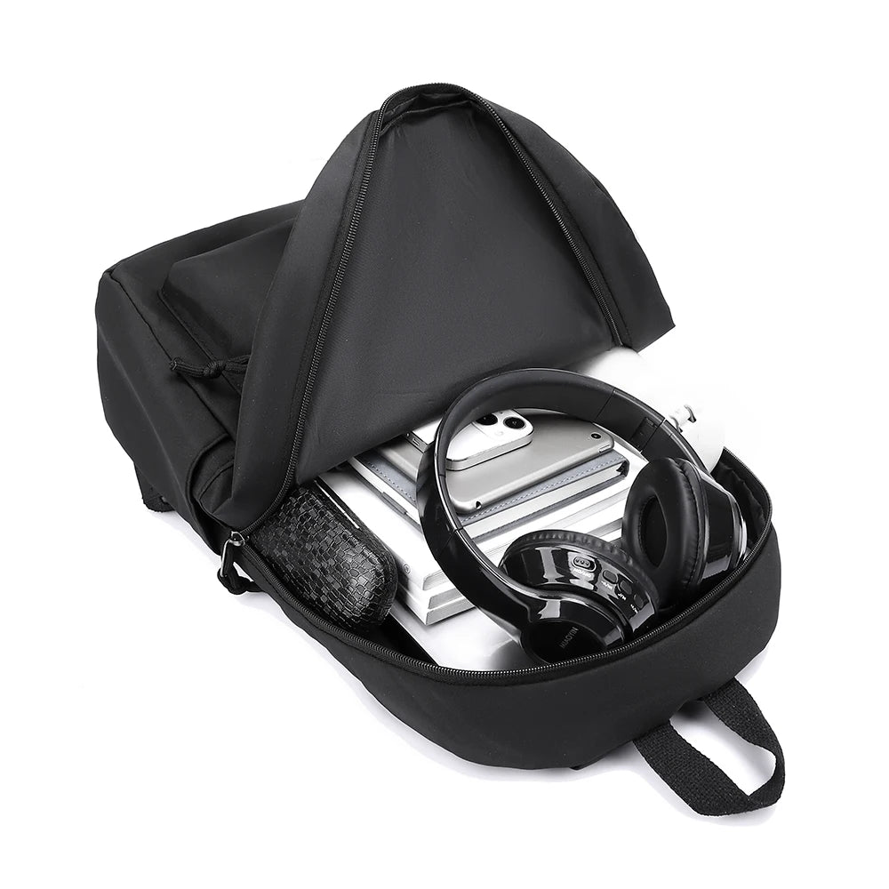 Black minimalist canvas backpack shown open, displaying a pair of black headphones.