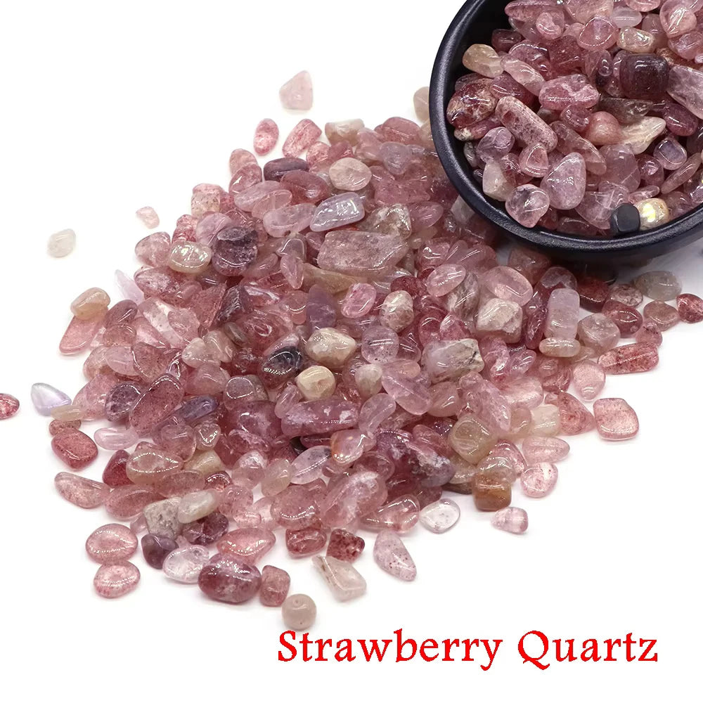 A pile of pink strawberry quartz crystal chips and tumbled stones in a black bowl.