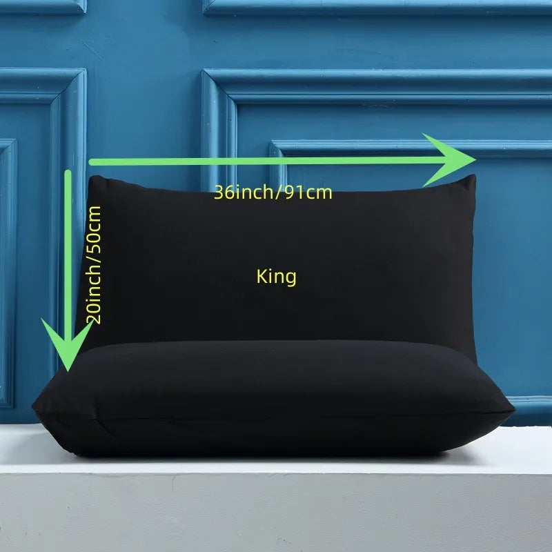 A black king size pillow is displayed against a blue paneled wall with dimension markings.