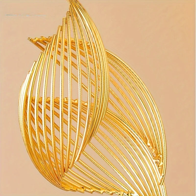 A close-up of a golden Nordic ceramic sculpture featuring vertical, flowing lines.