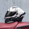 A black and white DOT-approved modular flip-up motorcycle helmet resting on a reddish-brown leather surface.