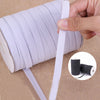 A hand is unwrapping a roll of white polyester elastic bands for sewing and crafts.