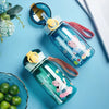 A collection of blue and pink cartoon-themed straw water bottles with leakproof lids resting on a light blue surface.