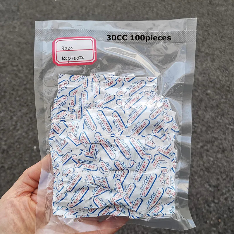 A clear plastic bag containing 300 food-grade oxygen absorbers, labeled as 100 pieces.
