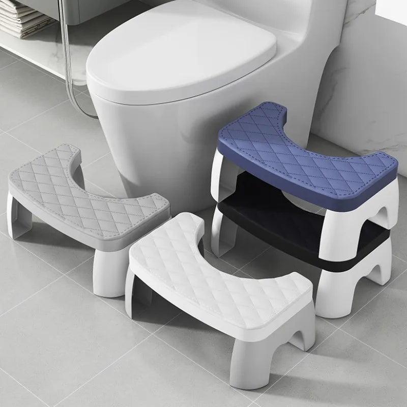 A set of white and blue ergonomic non-slip toilet squat stools shown on a gray floor.