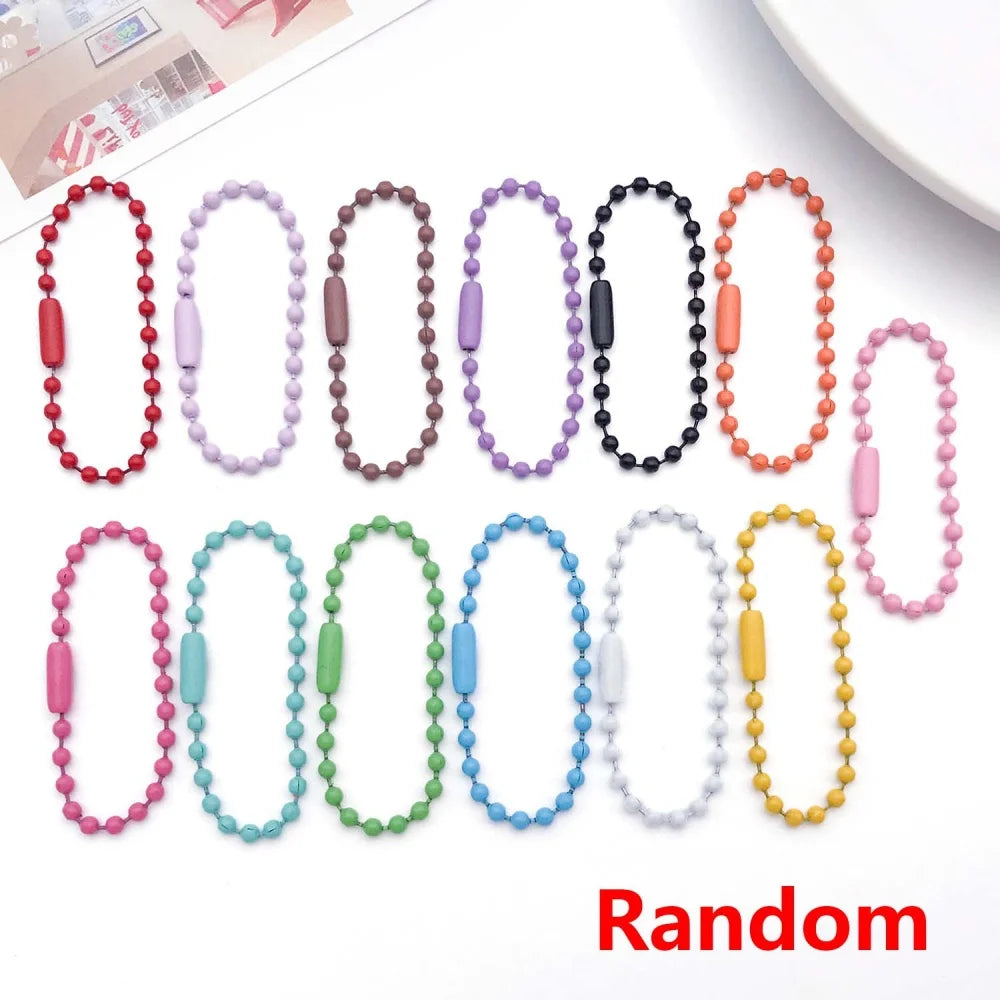A collection of 10 colorful ball bead chains in various colors and styles laid out for jewelry making.