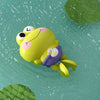A yellow cartoon turtle toy with a purple head and large eyes floats on green water.