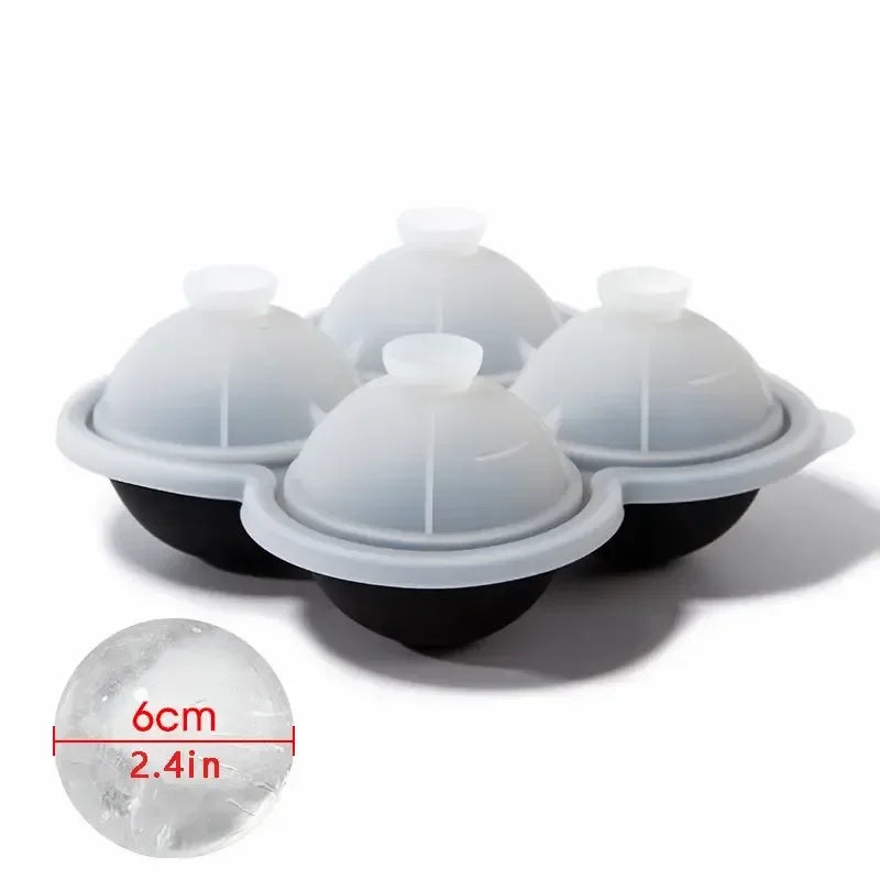 A set of white silicone ice cube trays with black bases and a clear ice cube shown next to a measurement ruler.