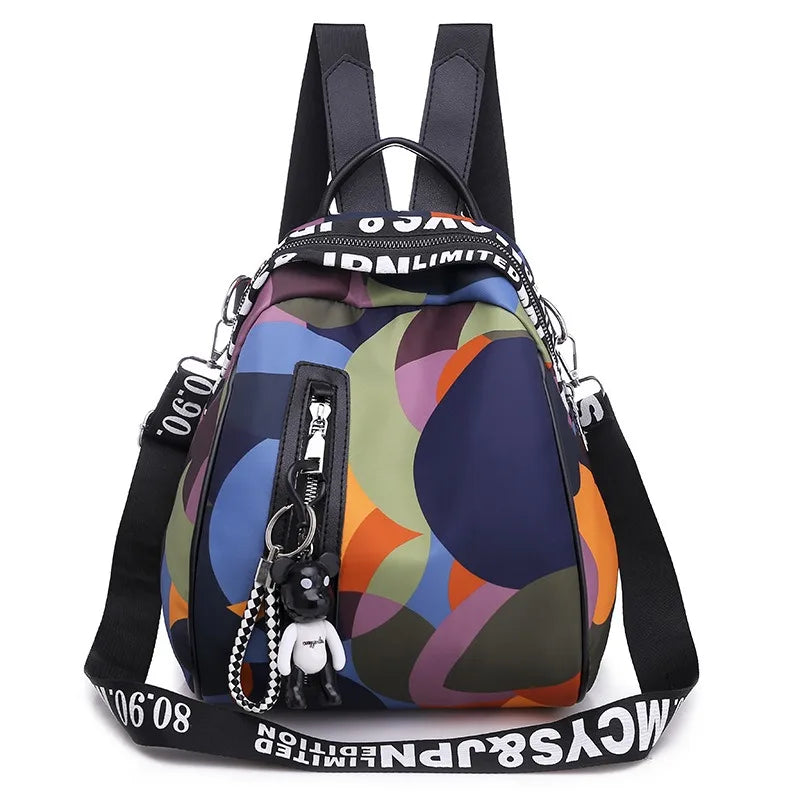 A dark blue and orange patterned backpack with black straps and a silver charm.
