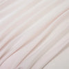 Close-up of a flowing, light pink bamboo flat sheet fabric draped softly.