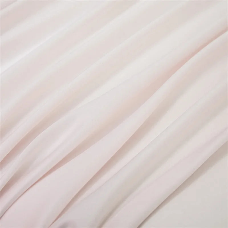 Close-up of a flowing, light pink bamboo flat sheet fabric draped softly.