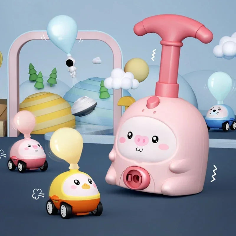A pink pig-shaped toy with a pump mechanism is surrounded by various balloon-powered racing cars and clouds.