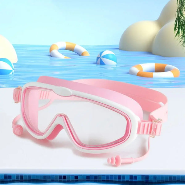 Pink anti-fog swim goggles resting on a white surface with blue water and inflatable rings in the background.