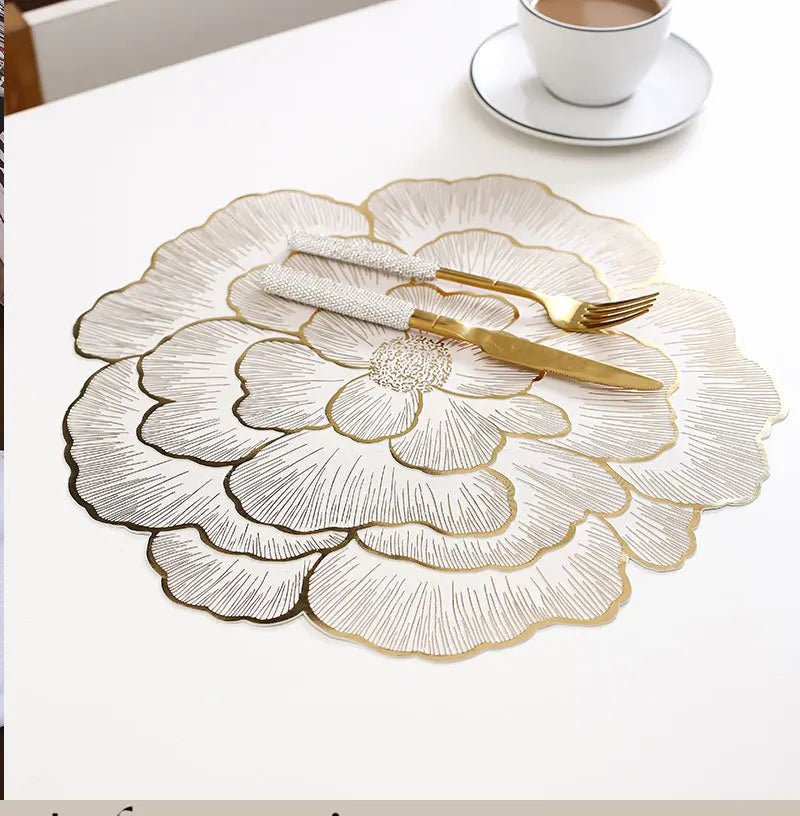 Goldvergoldete Pfingstrosen-Platzsets mit feiner Linienkunst und goldener Besteck auf weißem Tisch.