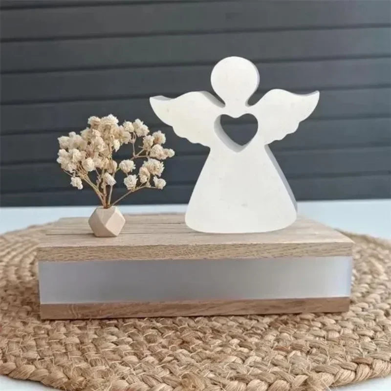 A white angel-shaped silicone mold for resin and crafting rests on a wooden block on a woven mat.