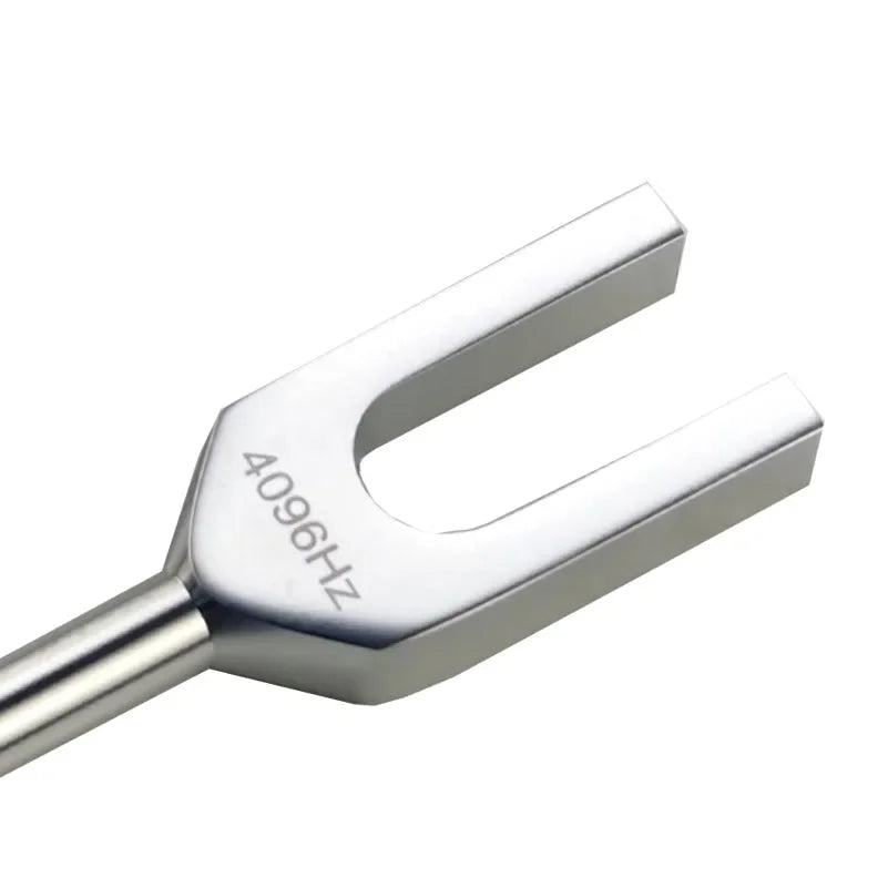 A silver tuning fork with a metal activator, used for sound healing.