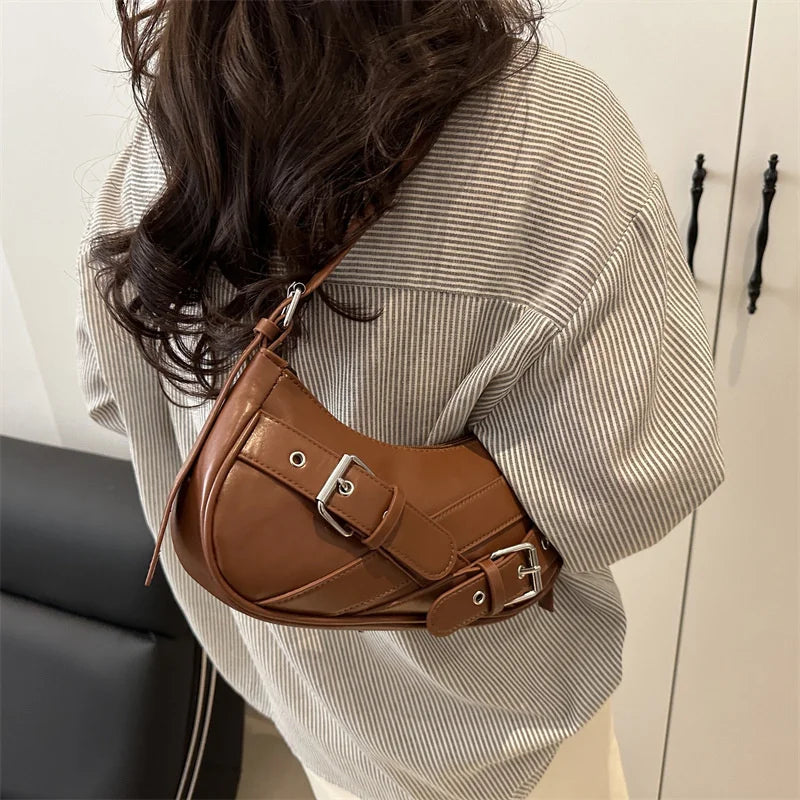 A brown PU leather crossbody bag worn by a person, featuring a flap closure and silver hardware.
