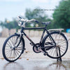 Schwarzes Vintage- Fahrrad mit silbernen Akzenten, draußen auf nasser Oberfläche fotografiert.