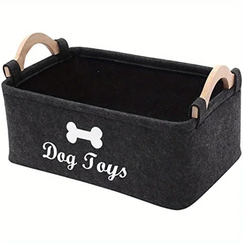A black felt storage basket with wooden handles for organizing dog toys.