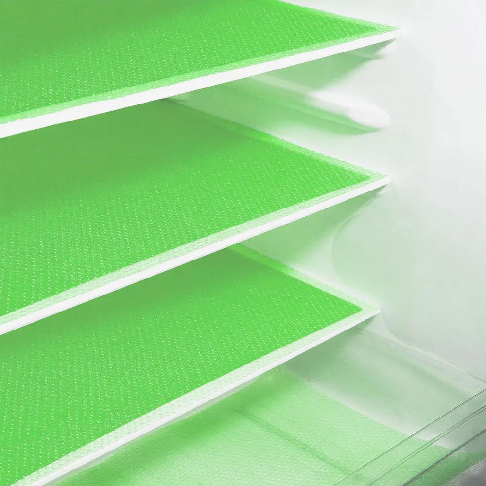 A close-up view of a white refrigerator shelf with bright green textured liners.