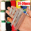 A hand holds a complete sewing needle kit with various needles, threader, and accessories alongside spools of colored thread.
