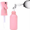 A pink ultra-fine mist spray bottle is being filled with liquid from a glass, demonstrating its use for hair, skin, and home 