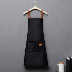 A black waterproof adjustable kitchen apron hanging on a wooden hanger.