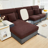 A dark brown elegant jacquard sofa slipcover with an elastic fit displayed in a bright living room.