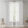 White vintage floral lace sheer curtains in two panels hanging over a window.
