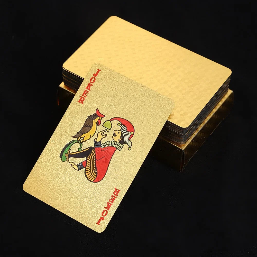 A deck of 24K gold waterproof playing cards is shown resting on a dark surface.