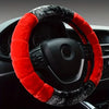 A black steering wheel covered with a red and gray plush material.