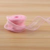 A roll of pink satin ribbon, 10 yards long and 40mm wide, lying on a wooden surface.