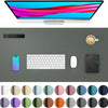 A computer monitor displaying colorful abstract lines, a blue smartphone, a white wireless mouse, and a black leather noteboo