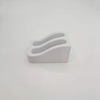 White wall-mounted wrench organizer rack with two curved slots.