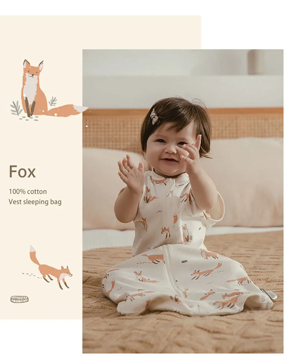 A baby wearing a white and orange patterned cotton vest sleeping bag on a brown blanket.